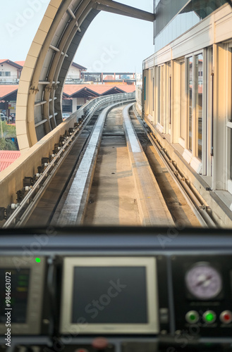 Obraz na płótnie View from inside airport train shows tracks curving ahead through a tunnel, with control panel in foreground, capturing the smooth journey and modern transit experience. w salonie