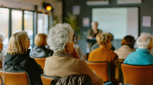 A group of retirees in a bright, airy community center, attending a workshop on Social Security benefits, with a speaker presenting information on a screen
