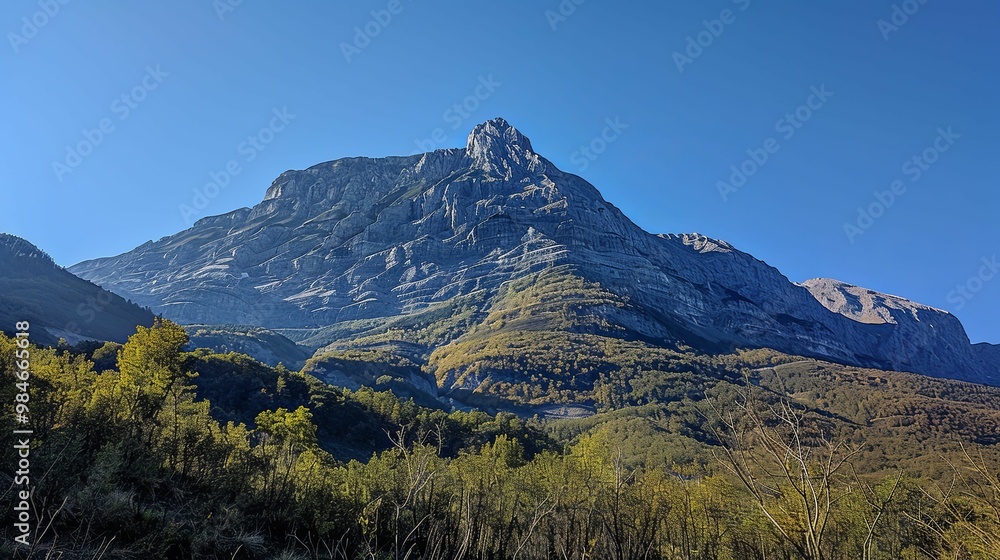 Majestic Mountain Peak with Forested Base Under a Clear Blue Sky Majestic Mountain Peak with Forested Base Under a Clear Blue Sky