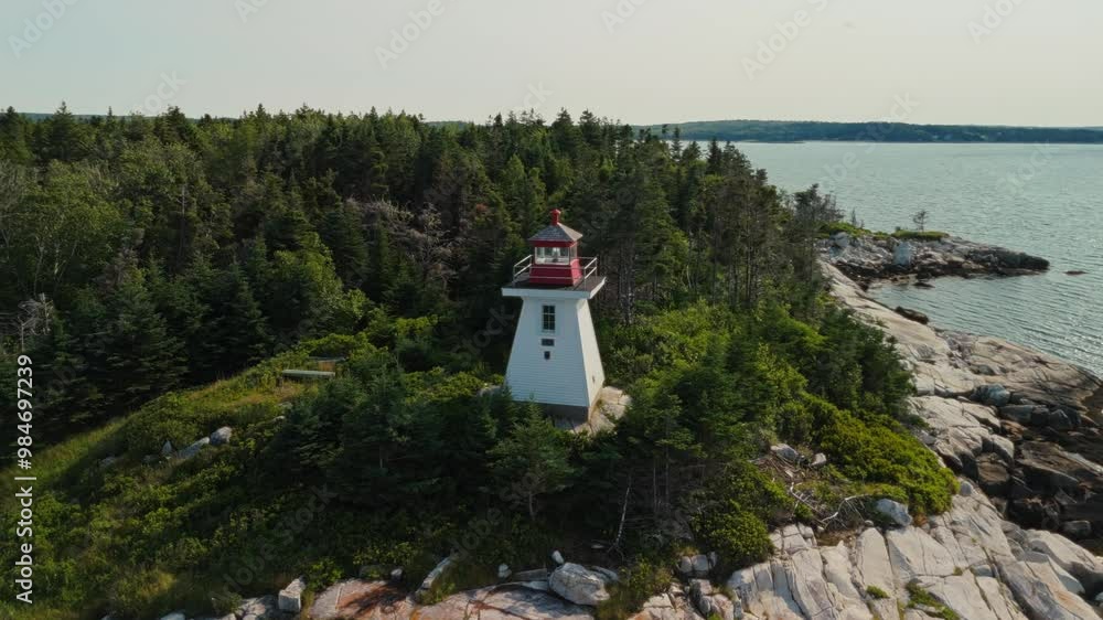 The Scenic Beauty Of The Port Mouton Lighthouse On A Small Nova Scotia Island Is Captured From Above, With The Ocean Waves Crashing Against The Rocky Shore. The Scenic Beauty Of The Port Mouton Lighthouse On A Small Nova Scotia Island Is Captured From Above, With The Ocean Waves Crashing Against The Rocky Shore.