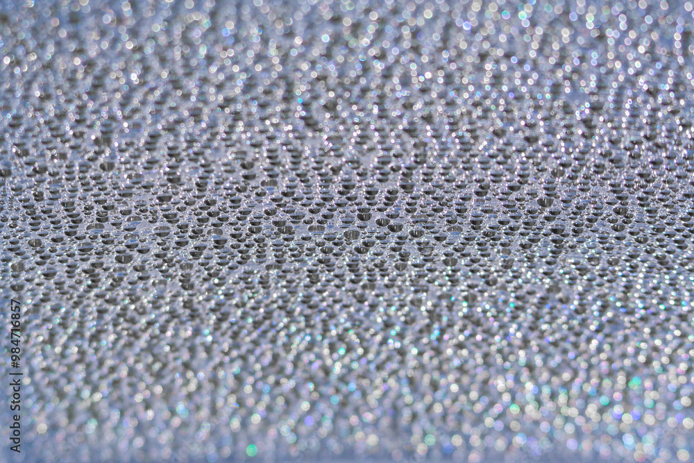 Blue water droplets on a piece of polycarbonate. Abstract background Blue water droplets on a piece of polycarbonate. Abstract background