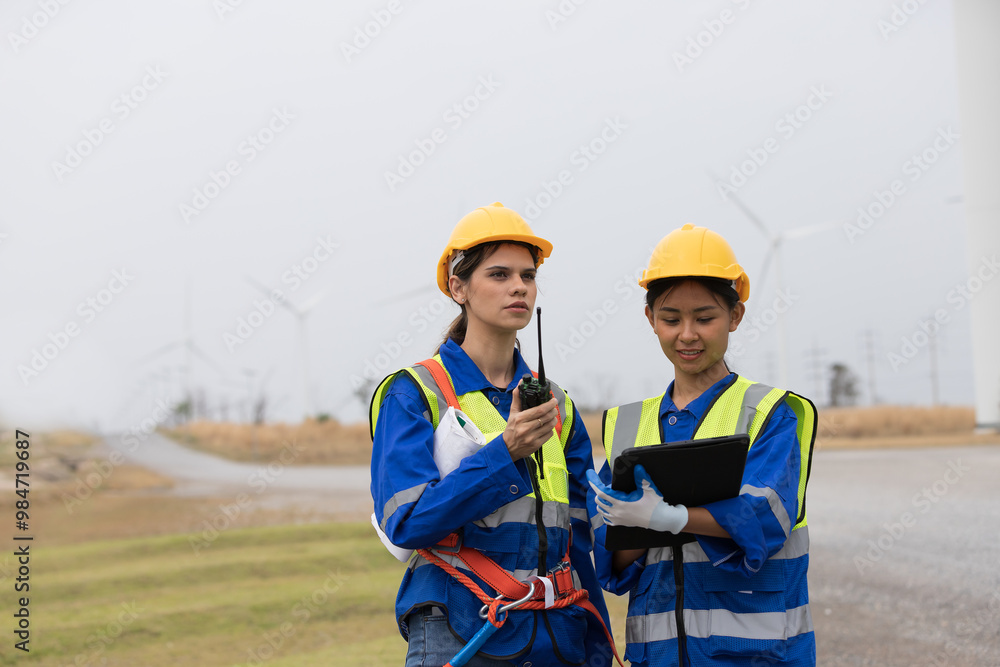 Group of female engineer working and inspecting quality of wind turbines at windmill field farm Group of female engineer working and inspecting quality of wind turbines at windmill field farm