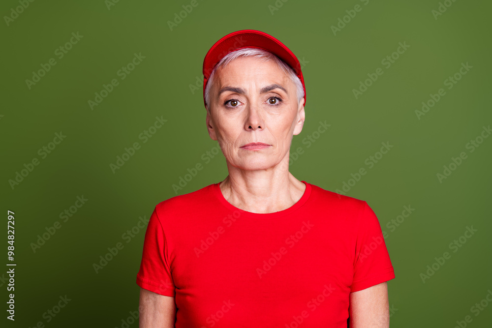 Photo of attractive mature woman professional delivery employee wear red uniform workwear isolated on khaki color background Photo of attractive mature woman professional delivery employee wear red uniform workwear isolated on khaki color background