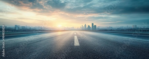 A serene cityscape at dawn, featuring a wide road leading toward the skyline under a cloudy sky.