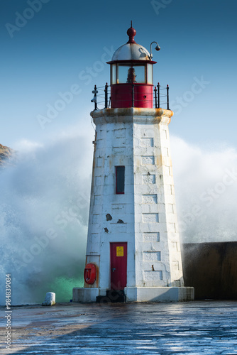 Waves crashing over the Lighthouse in Lybster Harbour photo