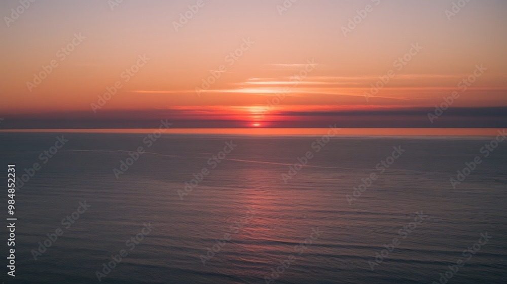 Fototapeta premium sun setting over ocean with tranquil waves and vibrant colors at twilight