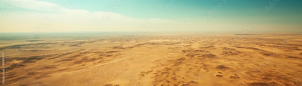 A breathtaking aerial view of a vast desert landscape under a clear blue sky, capturing the expansive beauty of the arid environment. A breathtaking aerial view of a vast desert landscape under a clear blue sky, capturing the expansive beauty of the arid environment.