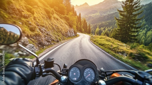 A motorcyclist riding through a winding mountain road, with scenic views of forests and valleys, capturing the freedom and adventure of the open road.