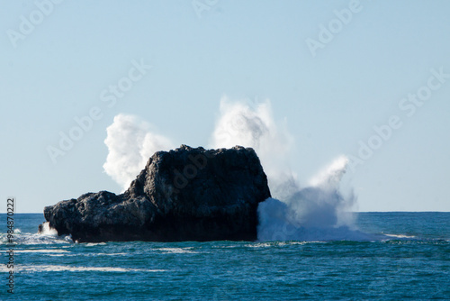 Waves crashing into a rock photo