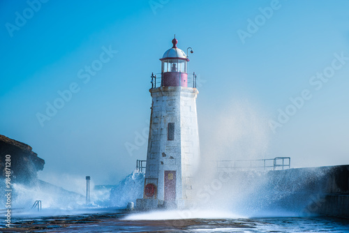 Lighthouse in Lybster Harbour during rough sea