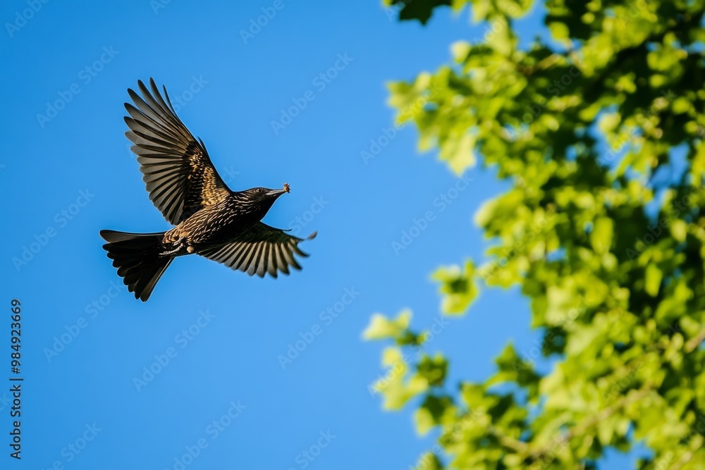 Obraz premium A bird soars gracefully against a bright blue sky. The vibrant green leaves highlight its beauty. This image captures nature in motion. Generative AI