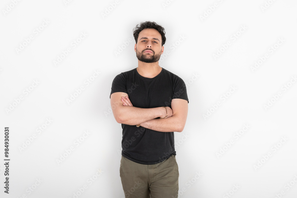 Portrait of young man with arms crossed looking at camera Portrait of young man with arms crossed looking at camera
