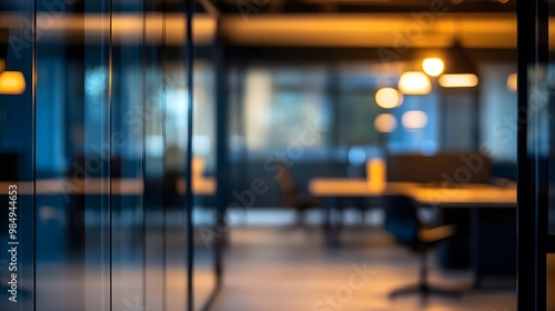 A blurred background of an office interior with glass walls, modern furniture, and desks