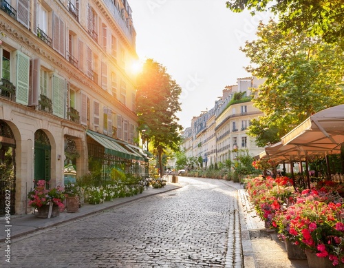 Charmante rue pavée de Paris, avec des fleurs et des boutiques.