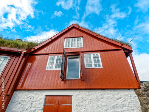 Scandinavian Style Buildings Against a Blue Cloudy Sky in Tórshavn, the capital city of the Faroe Islands Natural grass rooftops. Part of Tinganes - the historic location of the Faroese government.