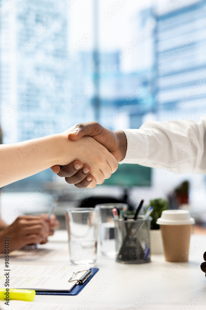 Team leader shaking hands with newly hired employee, welcoming him, close up shot. Businesspeople meeting, doing greeting handshake gesture in office workspace before starting negotiations Team leader shaking hands with newly hired employee, welcoming him, close up shot. Businesspeople meeting, doing greeting handshake gesture in office workspace before starting negotiations