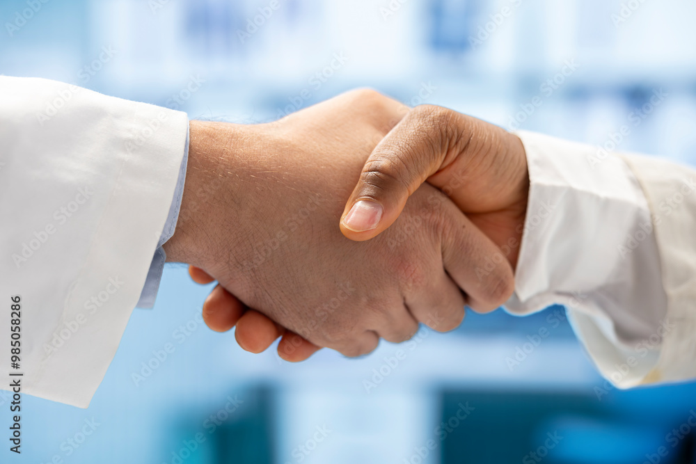 Diverse medics shaking hands after a successful treatment plan collaboration during a meeting with licensed physicians. Doctors with expertise doing a handshake for great partnership. Close up. Diverse medics shaking hands after a successful treatment plan collaboration during a meeting with licensed physicians. Doctors with expertise doing a handshake for great partnership. Close up.