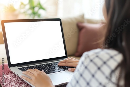 This mockup depicts a young woman using a laptop computer at home. The screen is blank and empty. Freelancing, student lifestyle, education, web conferencing, video calls, technology, and online