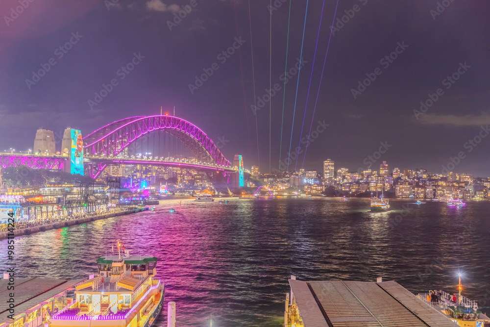 Obraz premium Colourful Light show at night on Sydney Harbour NSW Australia. The bridge illuminated with lasers and neon coloured lights for the Sydney Vivid light show
