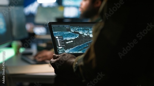 Fotografia Army telecommunication systems operator using satellite software on tablet, providing combat support