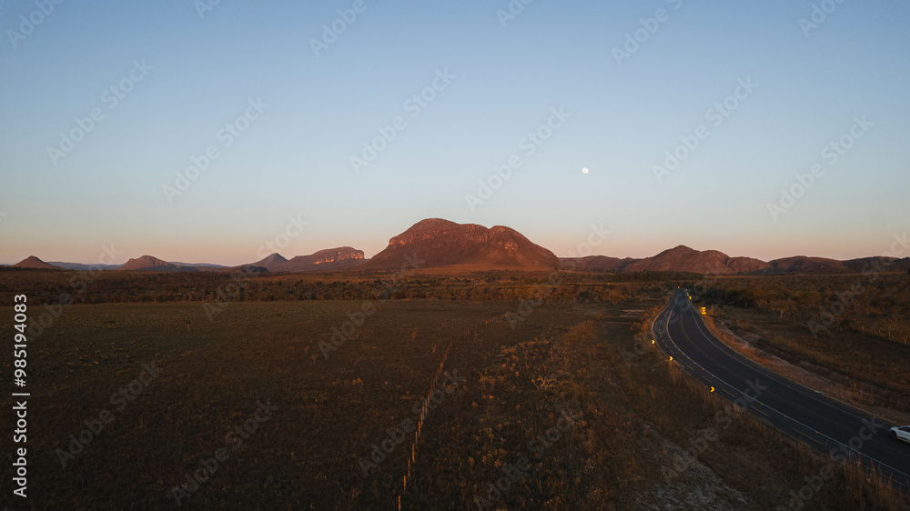 aerial view of highway with Morro da Baleia and fields, at sunset, Chapada dos Veadeiros, Goiás, Brazil aerial view of highway with Morro da Baleia and fields, at sunset, Chapada dos Veadeiros, Goiás, Brazil