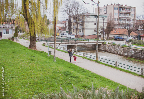 Mother and daughter are walking by the river photo