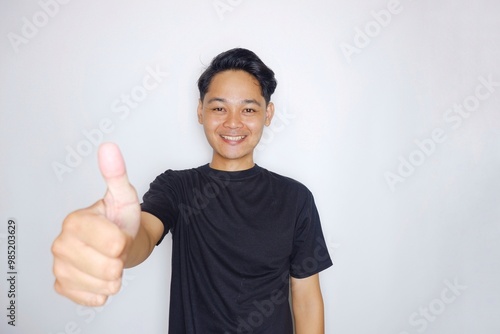 portrait of a handsome Indonesian man posing randomly wearing a black shirt on a white background isolated