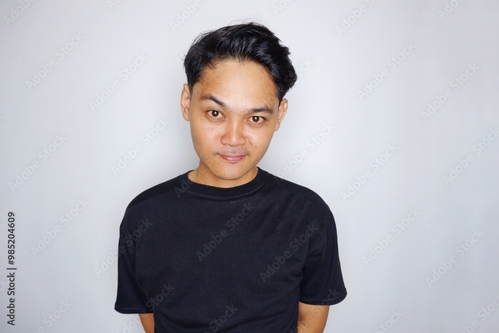 portrait of a handsome Indonesian man posing randomly wearing a black shirt on a white background isolated portrait of a handsome Indonesian man posing randomly wearing a black shirt on a white background isolated
