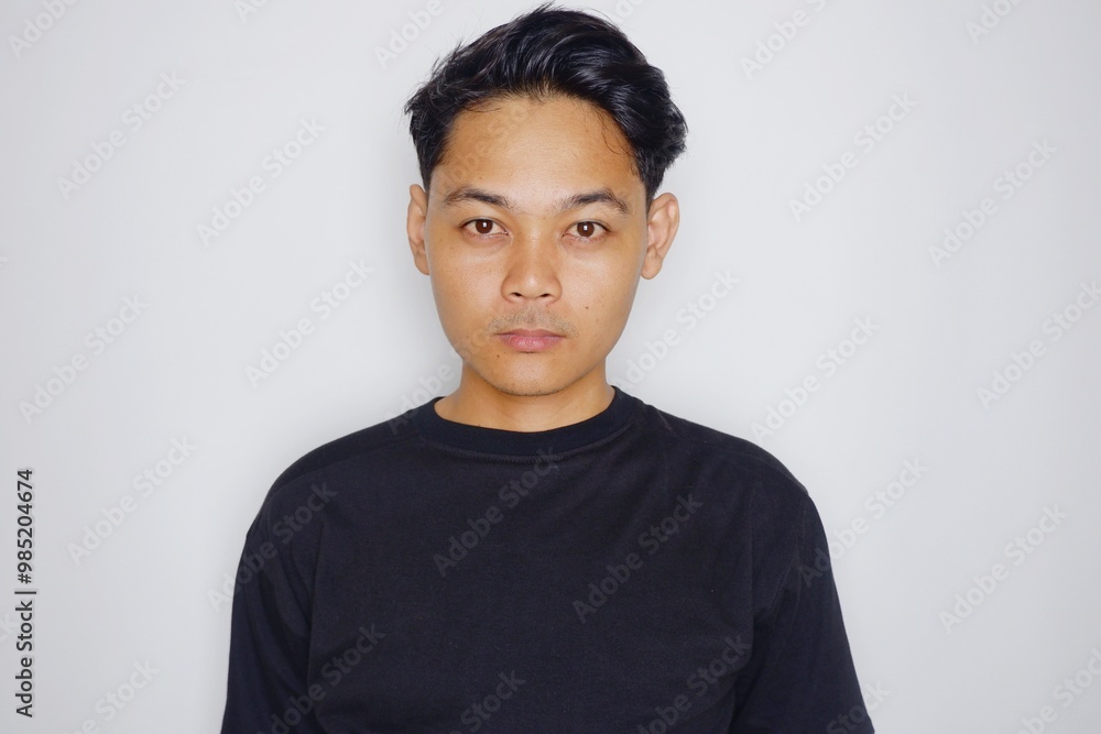 portrait of a handsome Indonesian man posing randomly wearing a black shirt on a white background isolated portrait of a handsome Indonesian man posing randomly wearing a black shirt on a white background isolated