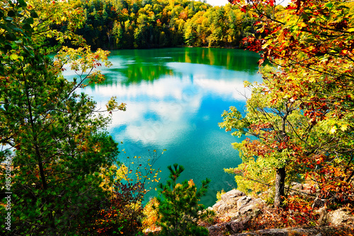 Scenic Pink Lake at Gatineau Park as seen from a rocky outcrop amidst magnificent red,orange and yellow fall colors during autumn season at Gatineau Park,Quebec,Canada photo