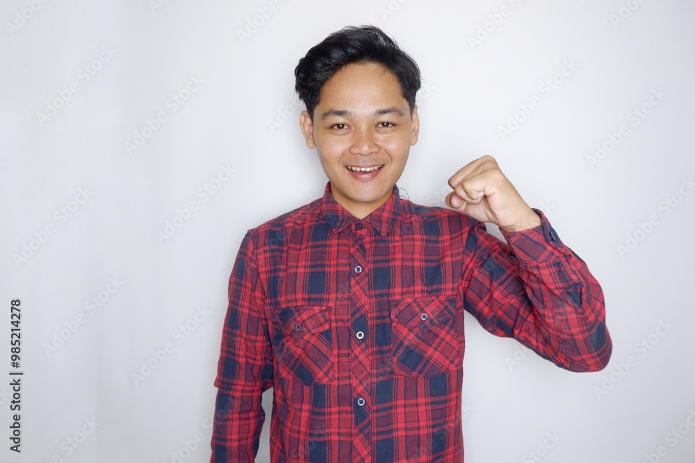 portrait of a handsome Indonesian man having a random expression wearing a checkered red flannel shirt on a white isolated background