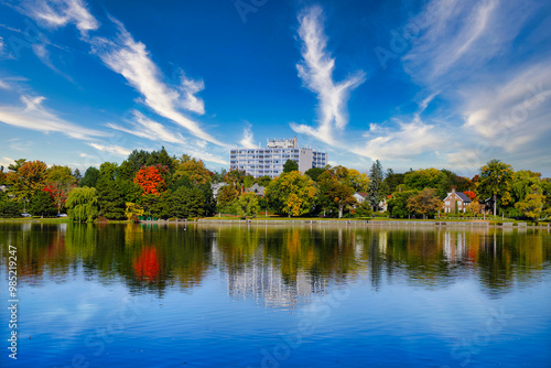 An Apartment building in the Glebe area amidst the changing colours of the Fall season with green,orange,red and yellow leaves on trees,wispy clouds in a blue sky in Autumn in Ottawa,Ontario,Canada 