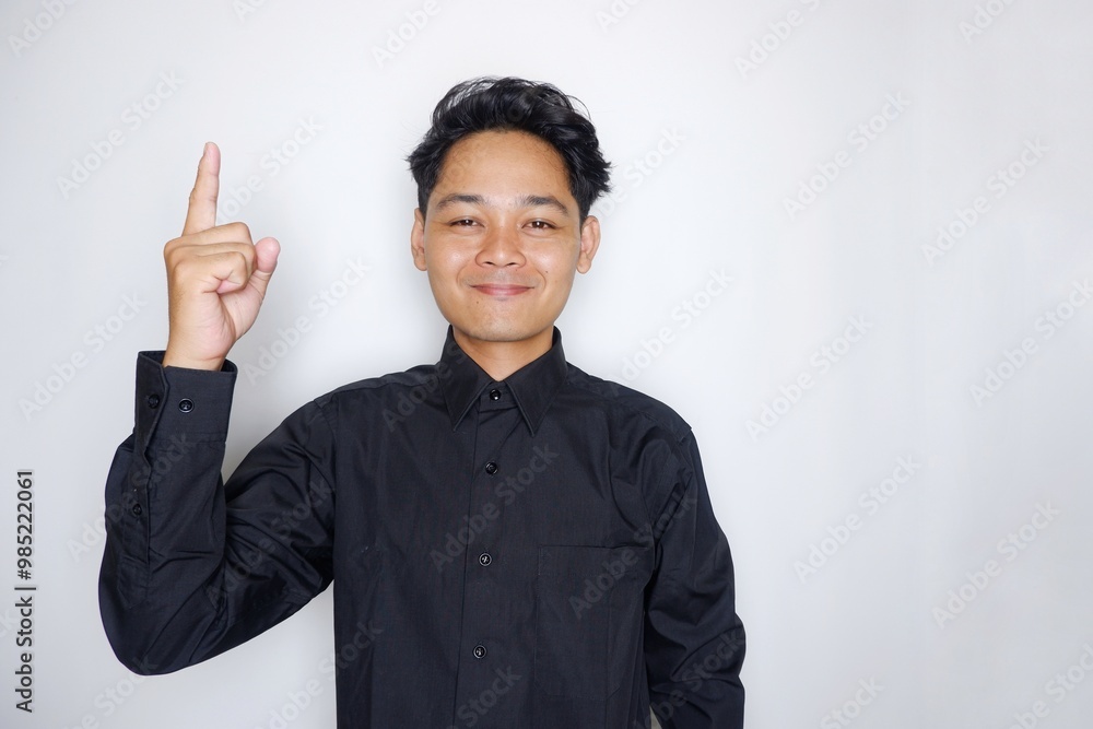 Portrait of a handsome Indonesian man wearing a plain black shirt with a random pose isolated on a white background Portrait of a handsome Indonesian man wearing a plain black shirt with a random pose isolated on a white background