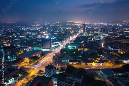 Aerial shot of Accra city at night. Modern Ghanaian architecture, cityscape, and infrastructure. Busy streets, roads, and railway lines. People and vehicles moving, city life.