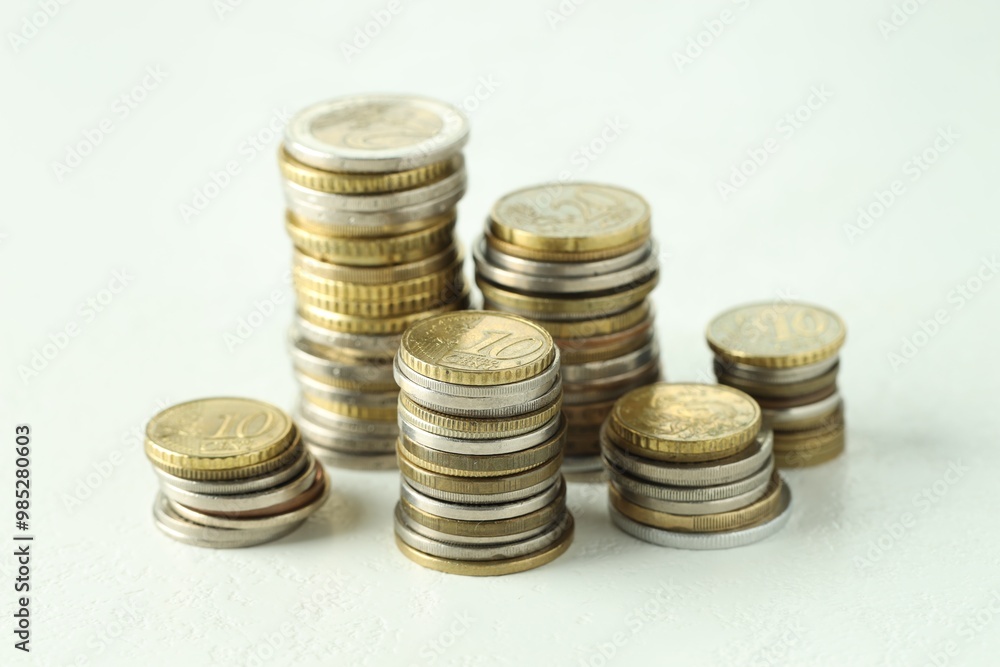 Stacks of euro coins on white textured table, closeup Stacks of euro coins on white textured table, closeup