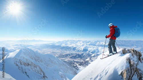 A skier stands on a snowy mountain peak, overlooking a breathtaking landscape below.