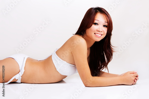 Young Slim Asian American Woman On Stomach In White Bikini