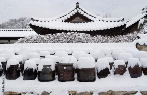 Jung-gu, Seoul, South Korea - February 4, 2013: Snow covered crocks(Jangdok) and roof tiles at Namsangol Hanok Village photo