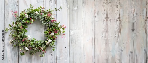 A wreath of flowers is hanging on a wooden wall