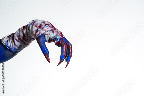Quadro em tela A blue witch hand with red nails, wrapped in a blood-stained bandage against a white background