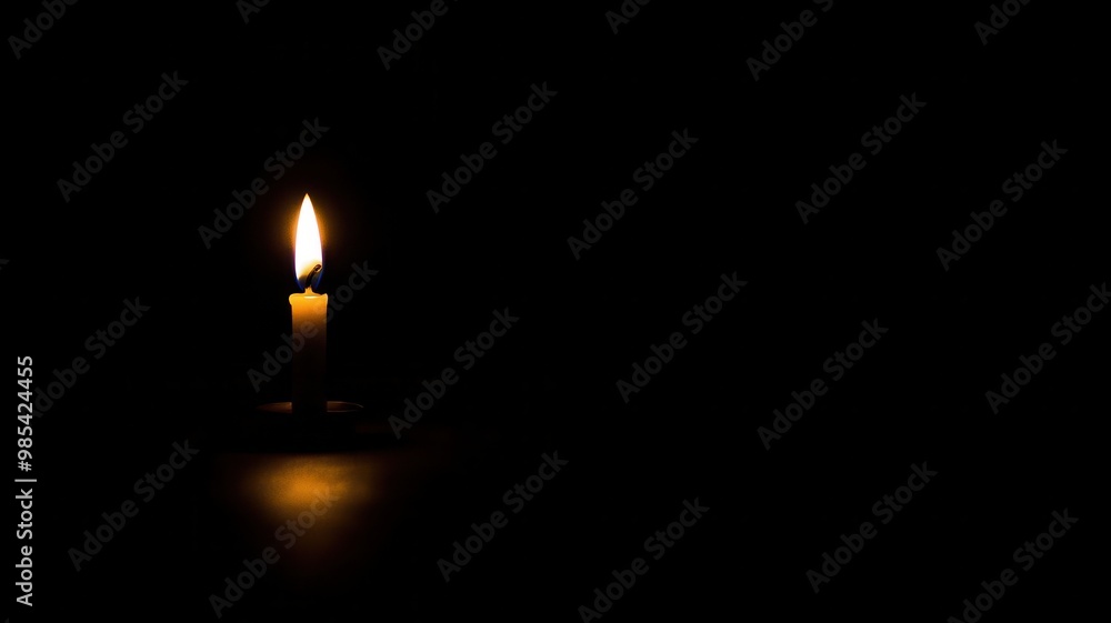 A solitary candle flickers in darkness, casting a warm glow and creating a serene ambiance. A solitary candle flickers in darkness, casting a warm glow and creating a serene ambiance.