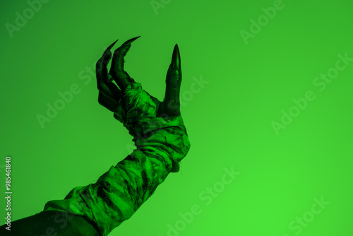 A bloodied witch hand wrapped in bandages, set against a green fire background. This demonic hand blends elements of vampires,aliens, and ghosts, evoking a spooky, monstrous feel perfect Halloween photo