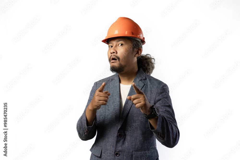 the happy expression of a boss pointing. stylish asian man with suit and orange helmet on white background. construction or mining business concept the happy expression of a boss pointing. stylish asian man with suit and orange helmet on white background. construction or mining business concept