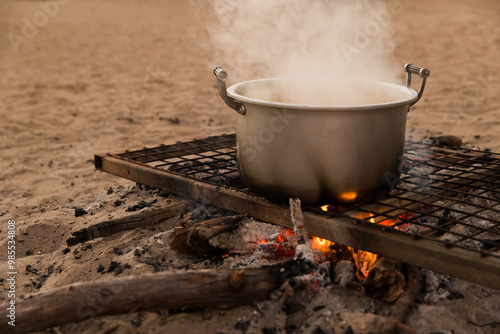 A metal pot on a grill over an open fire. photo