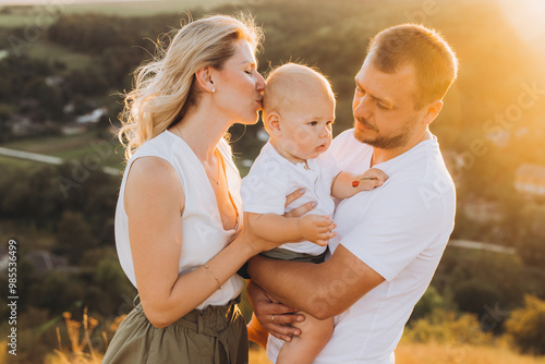 Loving Family Moment in Nature at Sunset with Parents and Baby photo