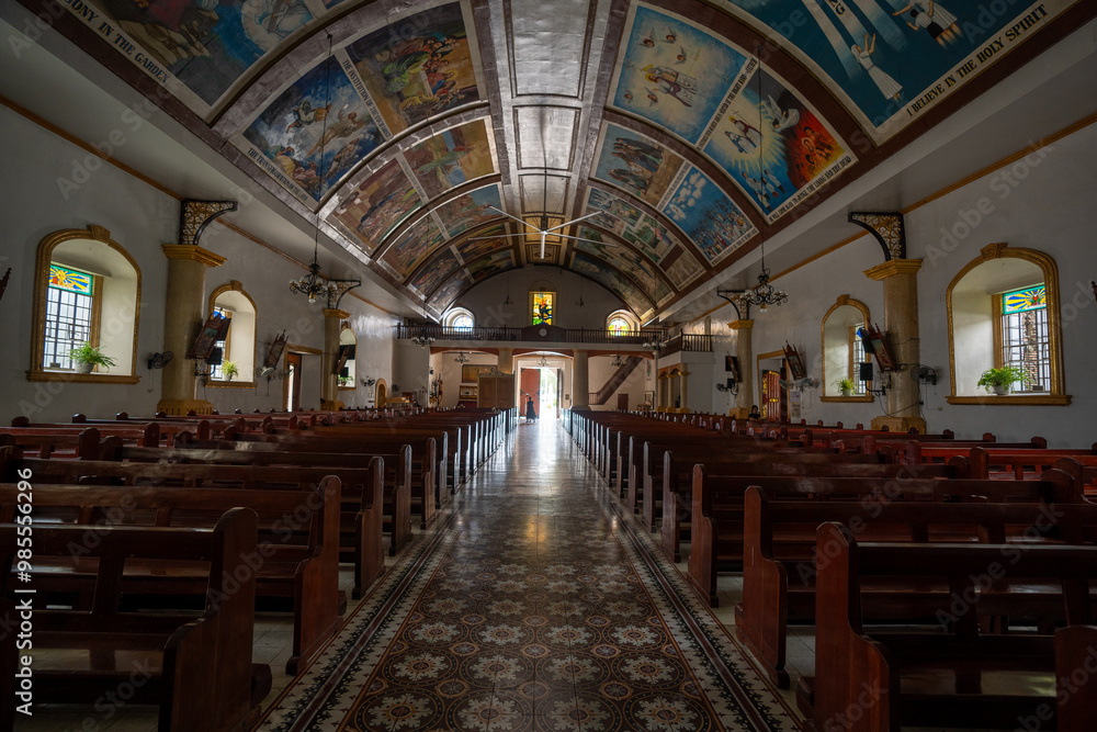 Fototapeta premium Interior of Bangar Church in Ilocos Sur, Philippines. Painting in the ceiling includes references to the power of the Holy Spirit, the body of the Virgin Mary, the finding of Jesus, and the temple