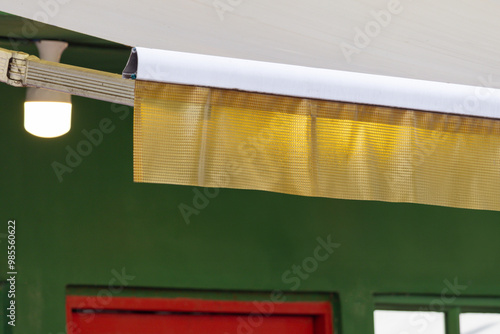 A white and gold curtain hangs from a white rod photo