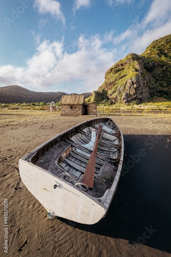 Old dinghy boat moored up on the beach in Whatipu, Auckland, New Zealand. photo