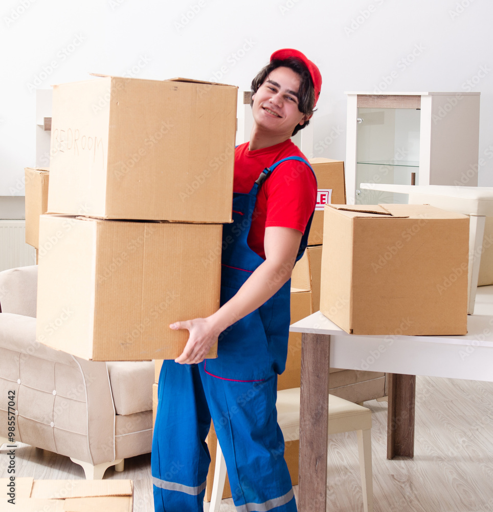 Young male contractor with boxes working indoors