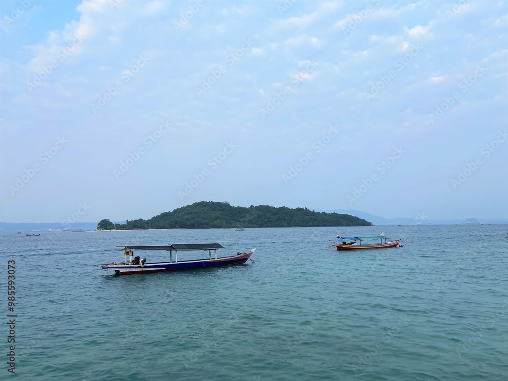 Obraz premium Bandar Lampung, Indonesia - September 1st 2024: Fishing boats are parked on the seashore in the afternoon with a cloudy sky in the background